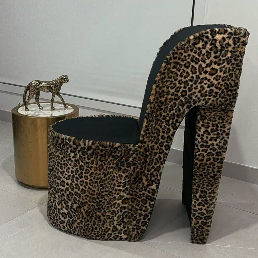 Leopard print high-heel shaped accent chair next to a gold marble side table
