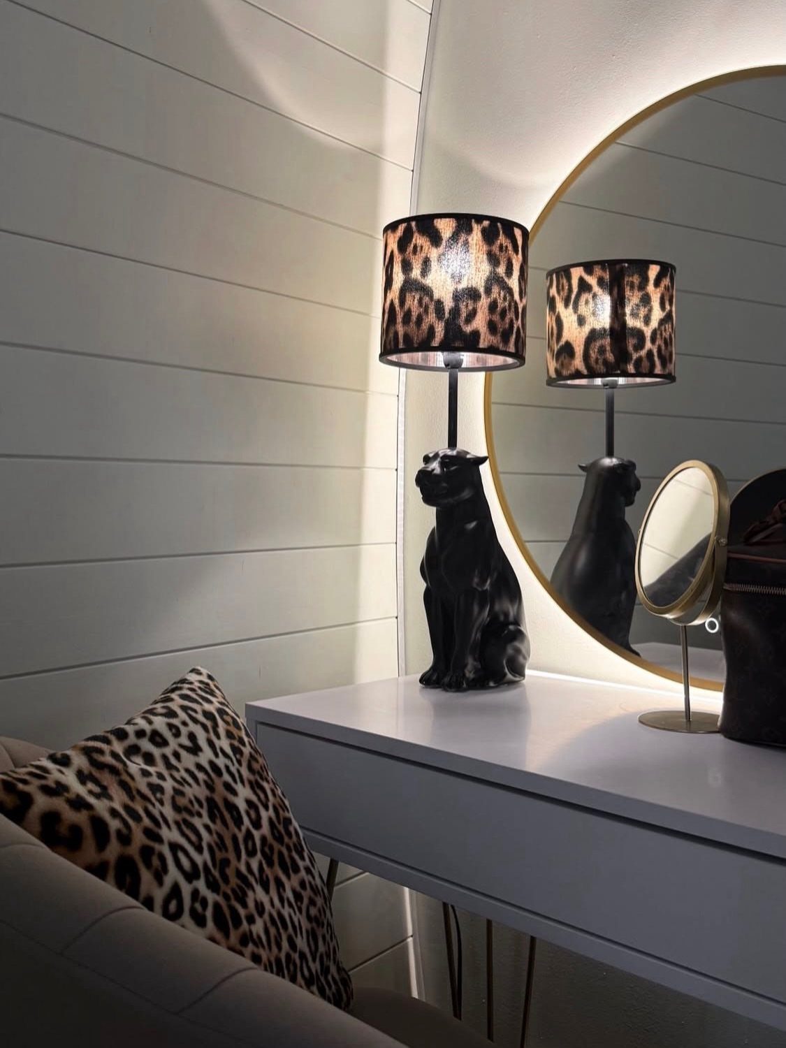 Leopard print lampshade on a dog lamp atop a white vanity desk.