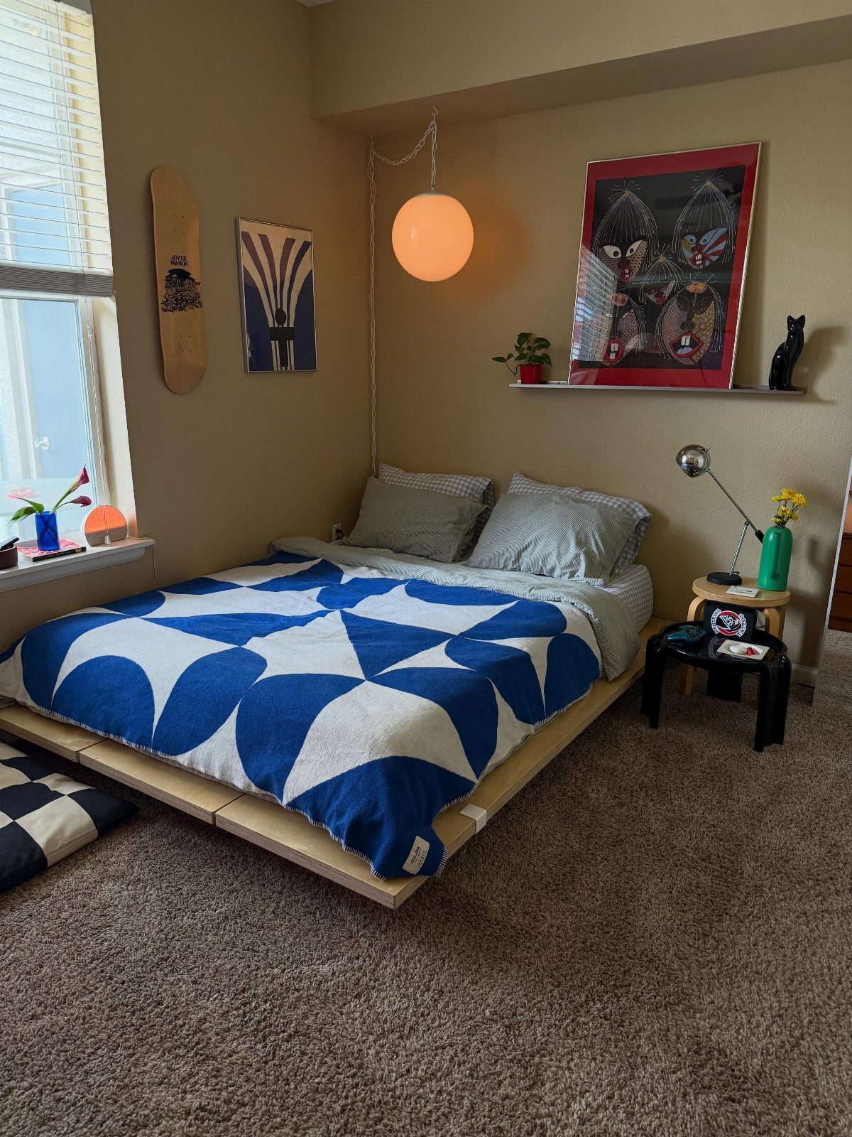 Low-profile wooden bed frame with blue geometric bedding in a modern bedroom