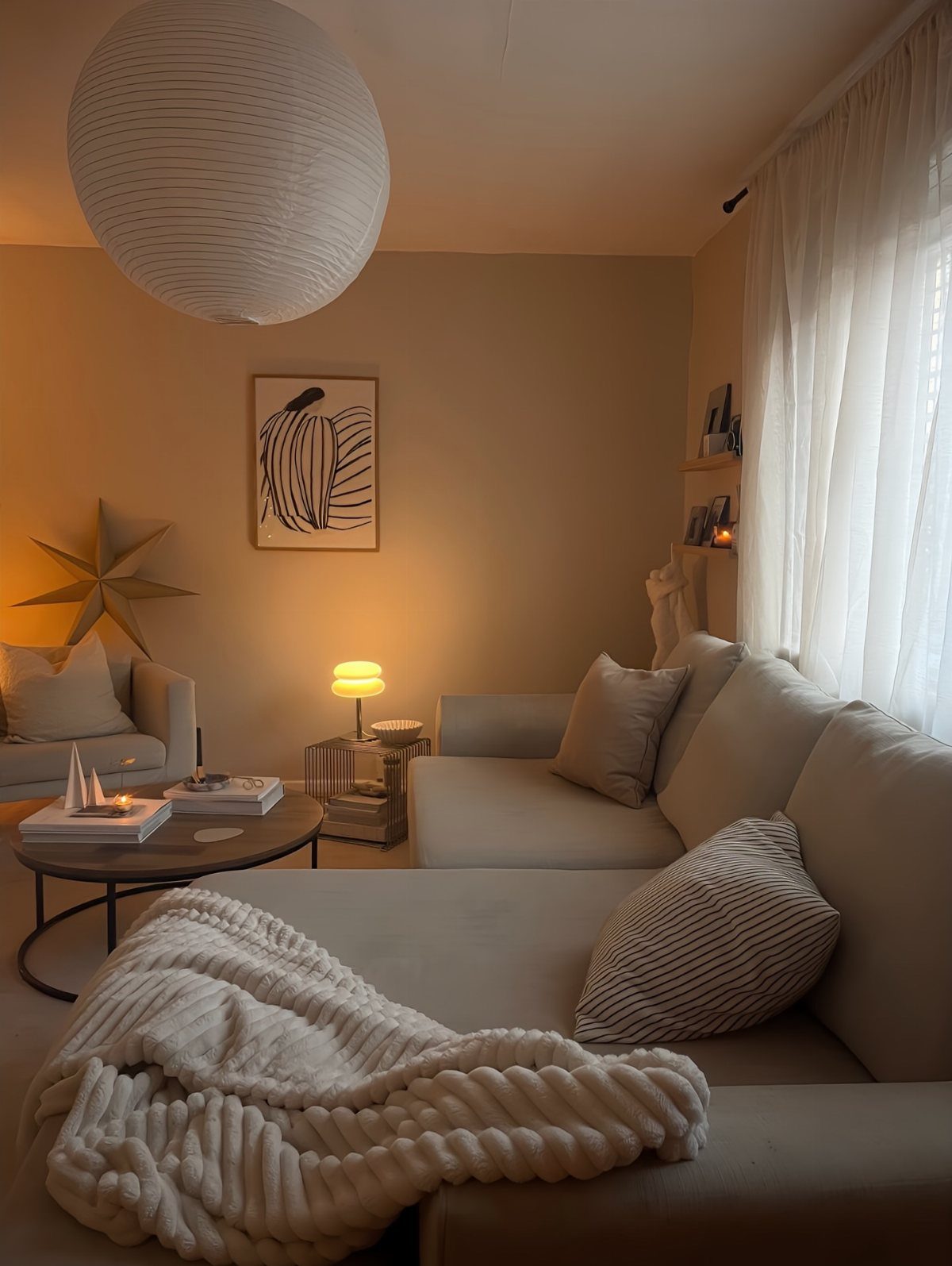 Beige sectional sofa with chunky knit throw and soft pillows in warm lighting.