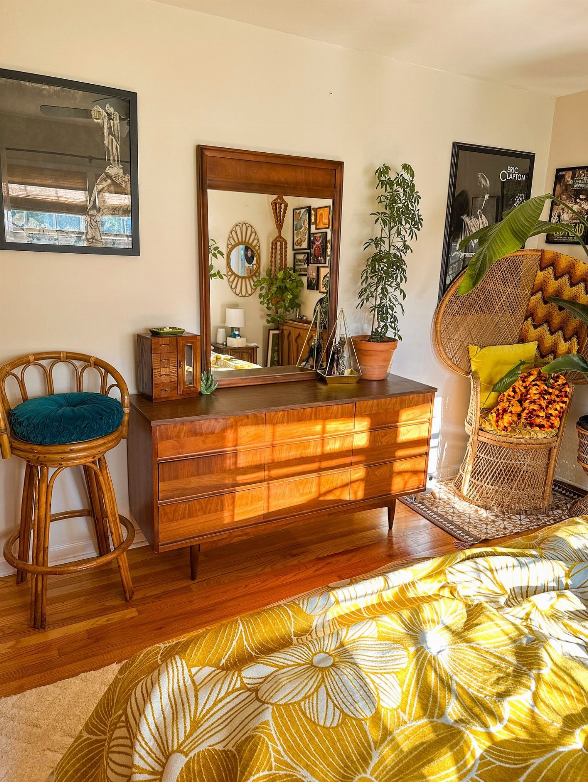 Mid-century modern wooden dresser and rattan furniture in a sunny, eclectic bedroom.