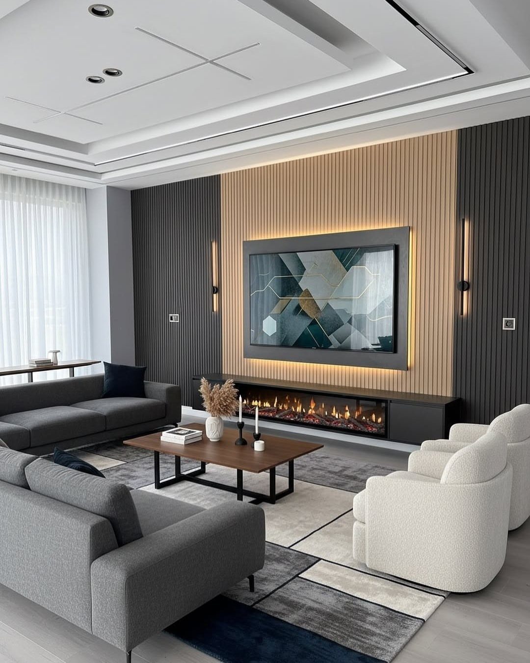 Modern living room with grey sofas, white armchairs, and a wood-slatted TV wall.