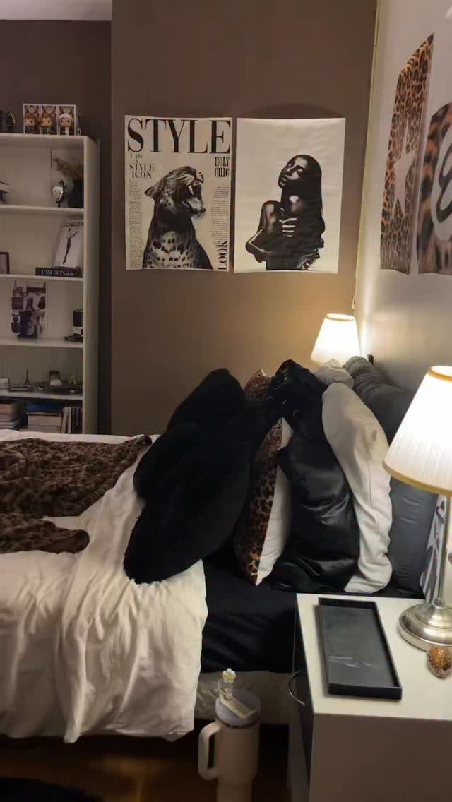 Black and white posters of a leopard and woman on a brown bedroom wall.