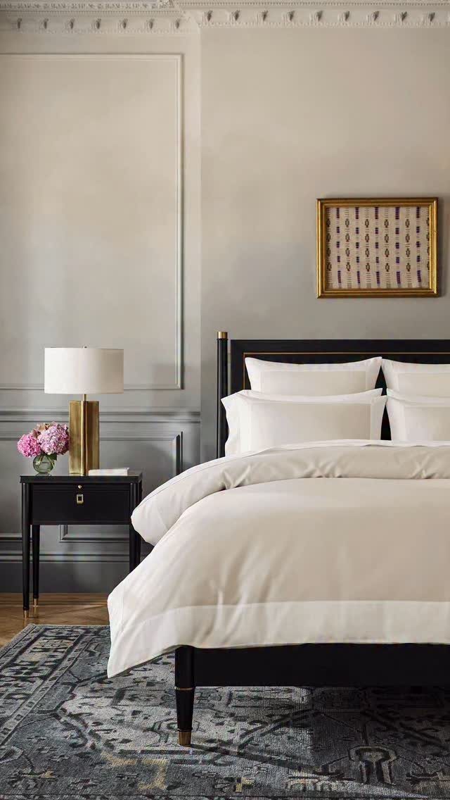 Bedroom with black and white decor featuring pink flowers as a pop of color.