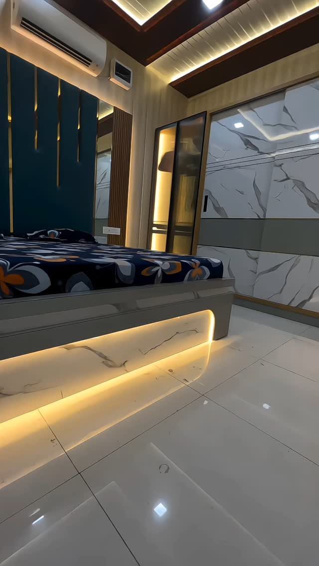 Modern bedroom with a grey bed, under-bed lighting, and blue accent wall.