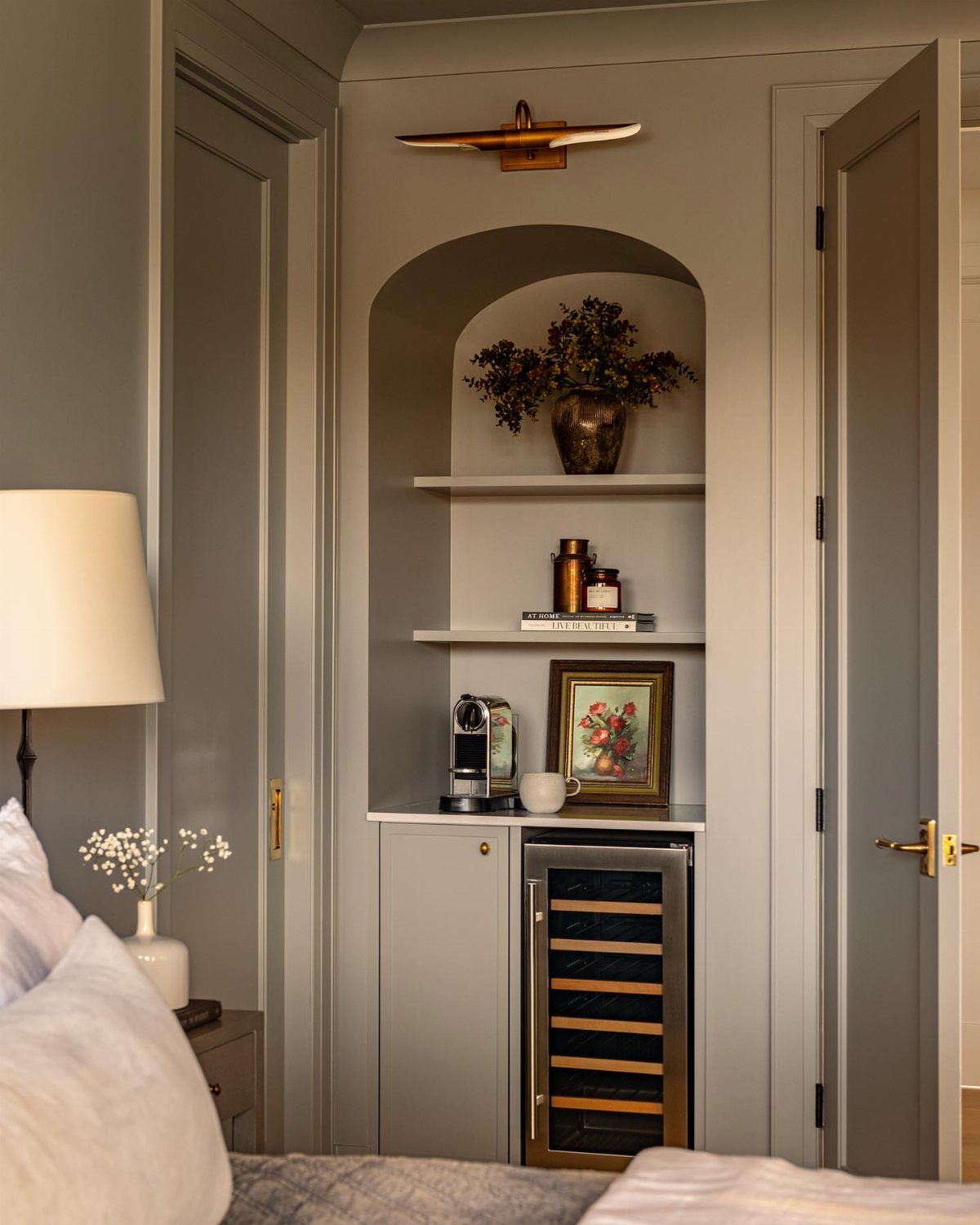 Built-in bedroom coffee station with a small espresso machine and wine cooler.