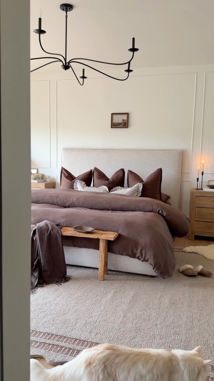 Beige textured rug on the floor of a bedroom with brown bedding.
