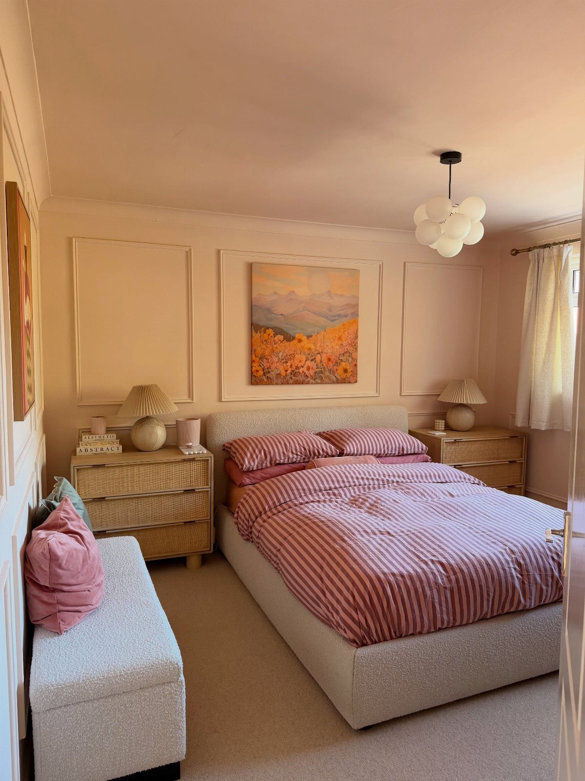 Bed with red and white striped duvet cover in a peach-toned bedroom.