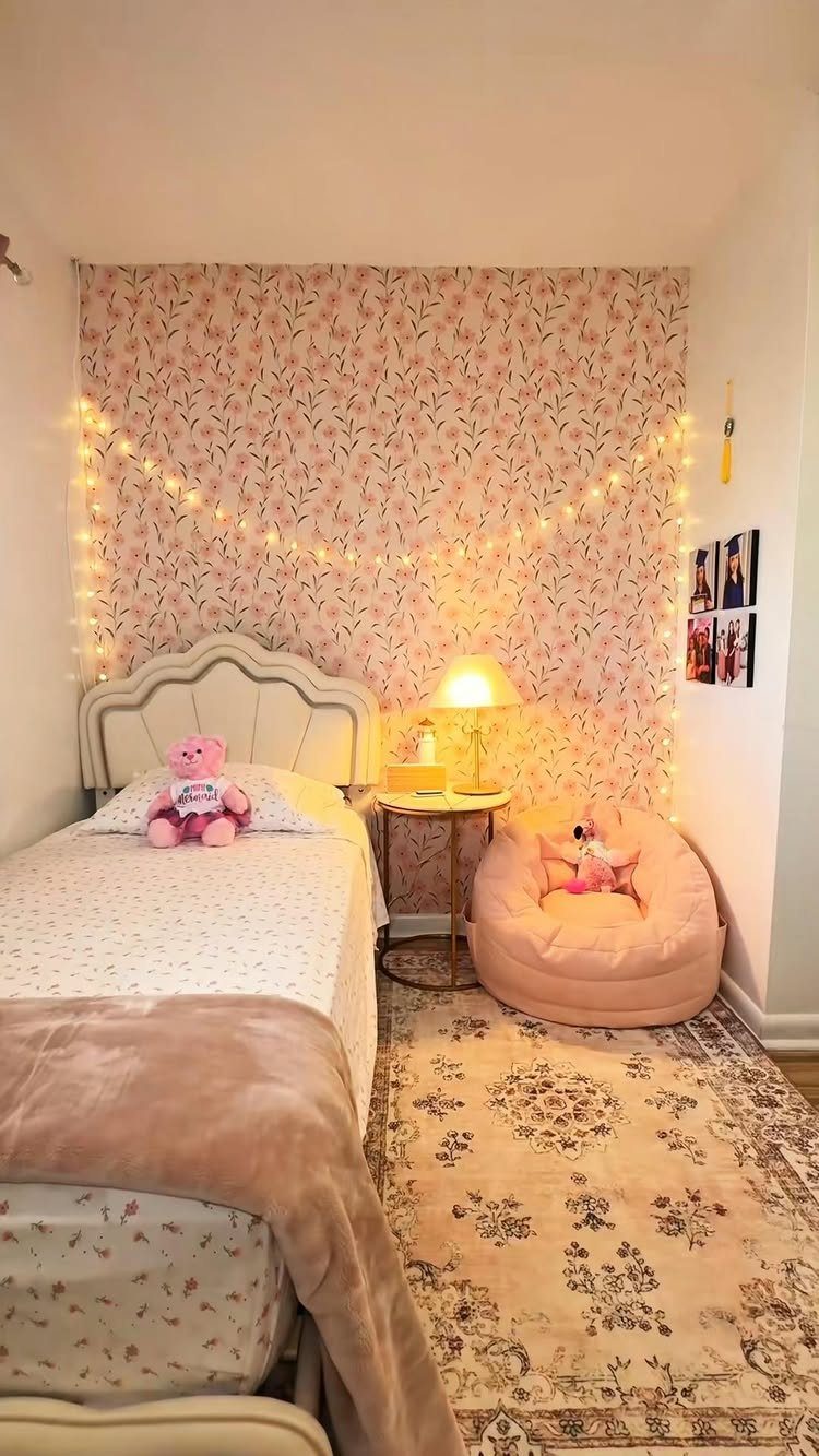 Bedroom with pink floral wallpaper, string lights, and a pink bean bag chair.
