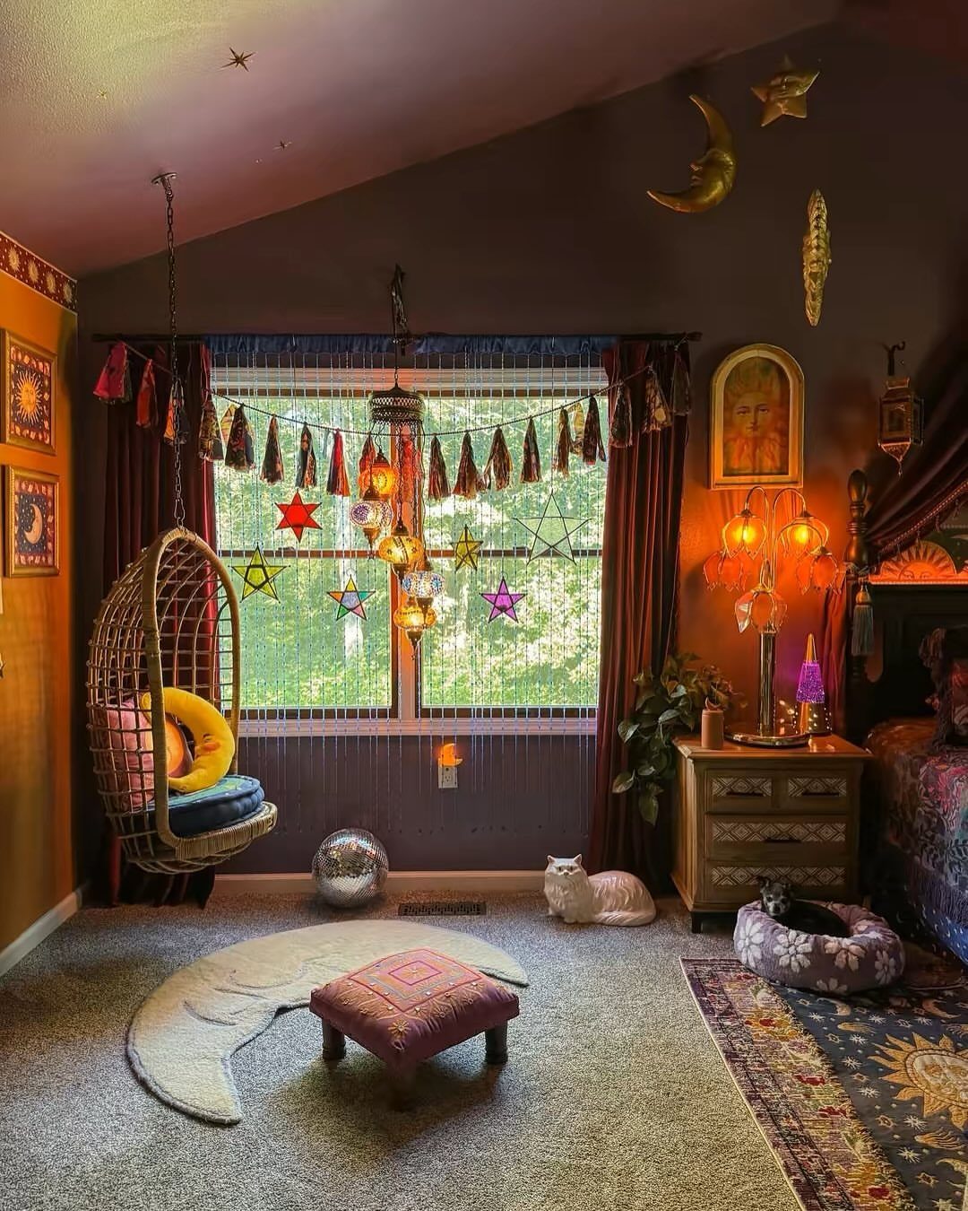 Bohemian bedroom with dark purple walls, hanging egg chair, and celestial decor.