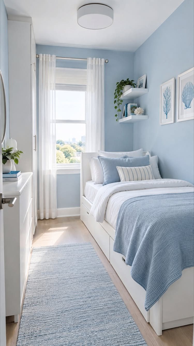 Light blue bedroom walls with white furniture and matching blue bedding and rug.