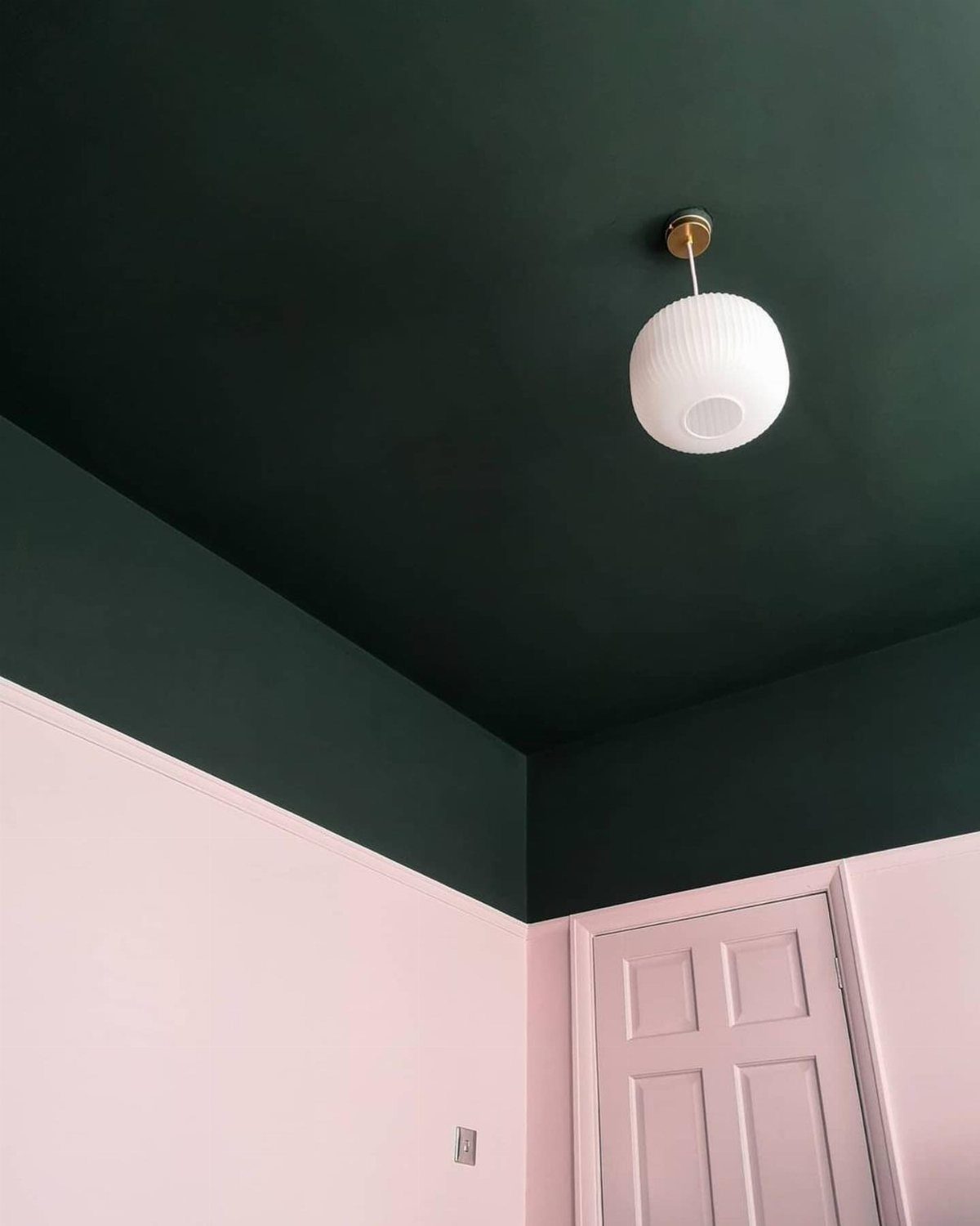 Dark green painted ceiling and upper walls contrasting with light pink lower walls.