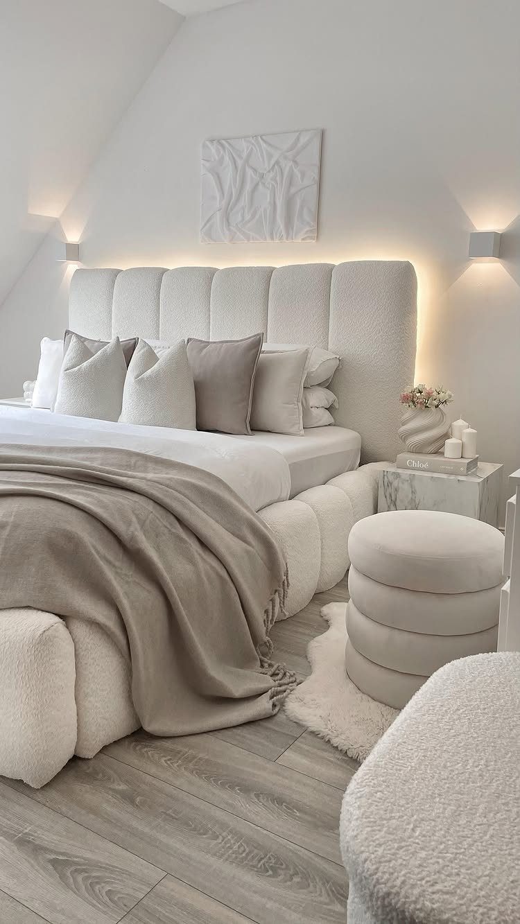 White bedroom walls with a tufted headboard and neutral beige bedding.