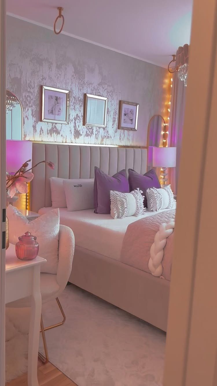 Bedroom with beige tufted headboard, purple pillows, and gold-framed art on textured walls.
