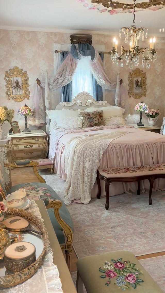 Ornate bedroom with vintage furniture, pink lace bedding, and a crystal chandelier.