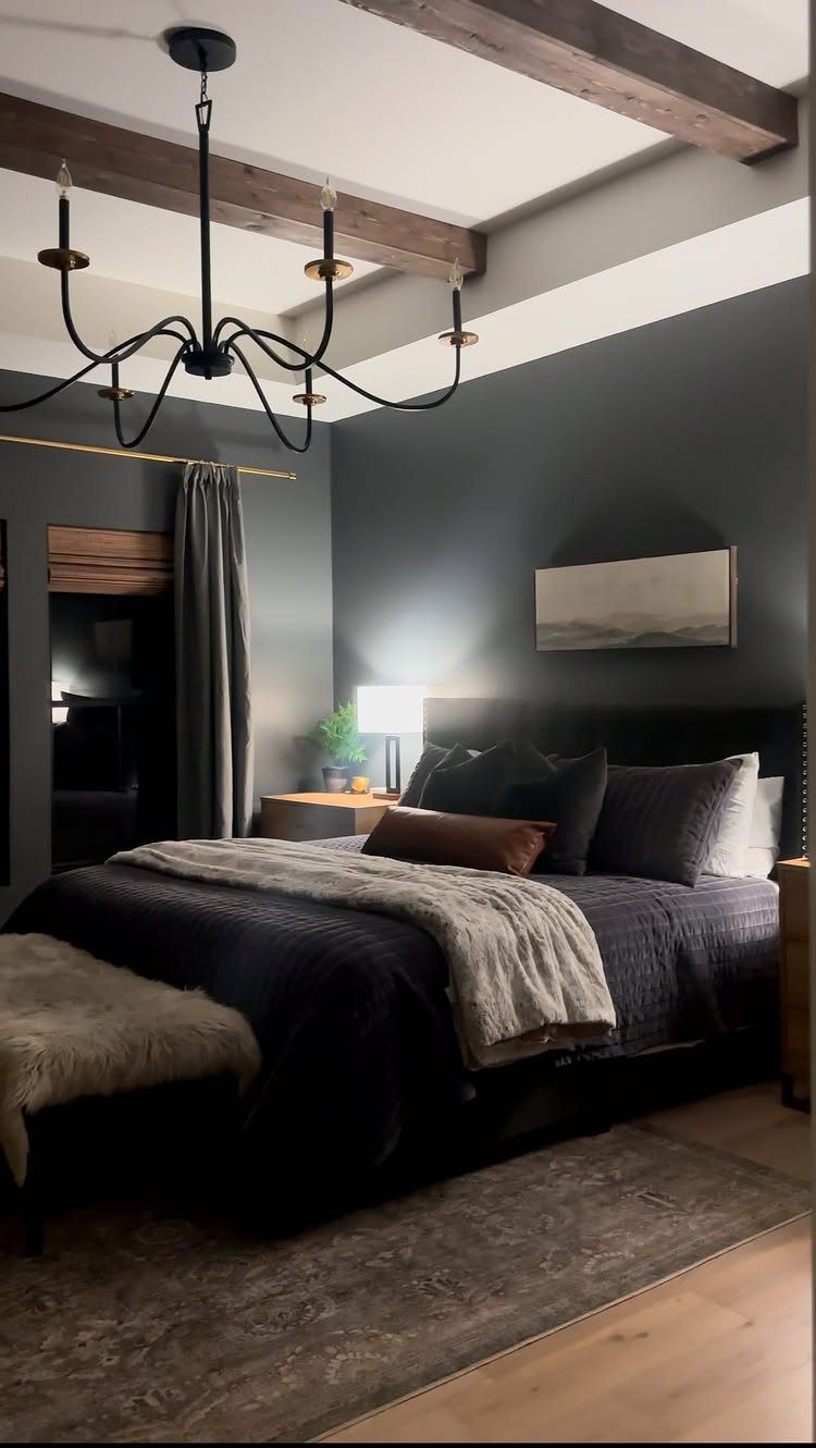 Dark gray bedroom walls with a charcoal bed and wooden ceiling beams.