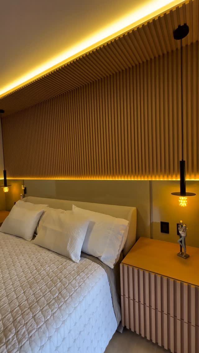 Modern bedroom with a vertical wood slat millwork feature wall and warm lighting.