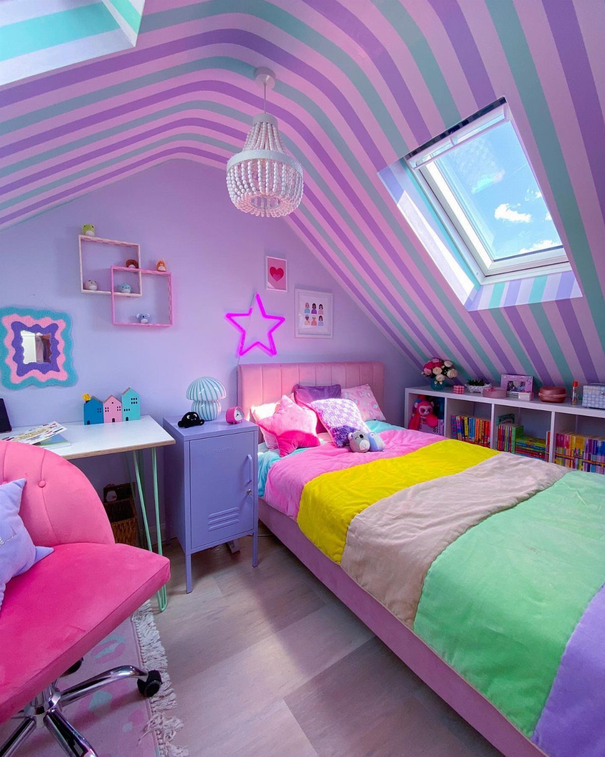 Vaulted bedroom ceiling painted with purple and teal stripes above a colorful bed.