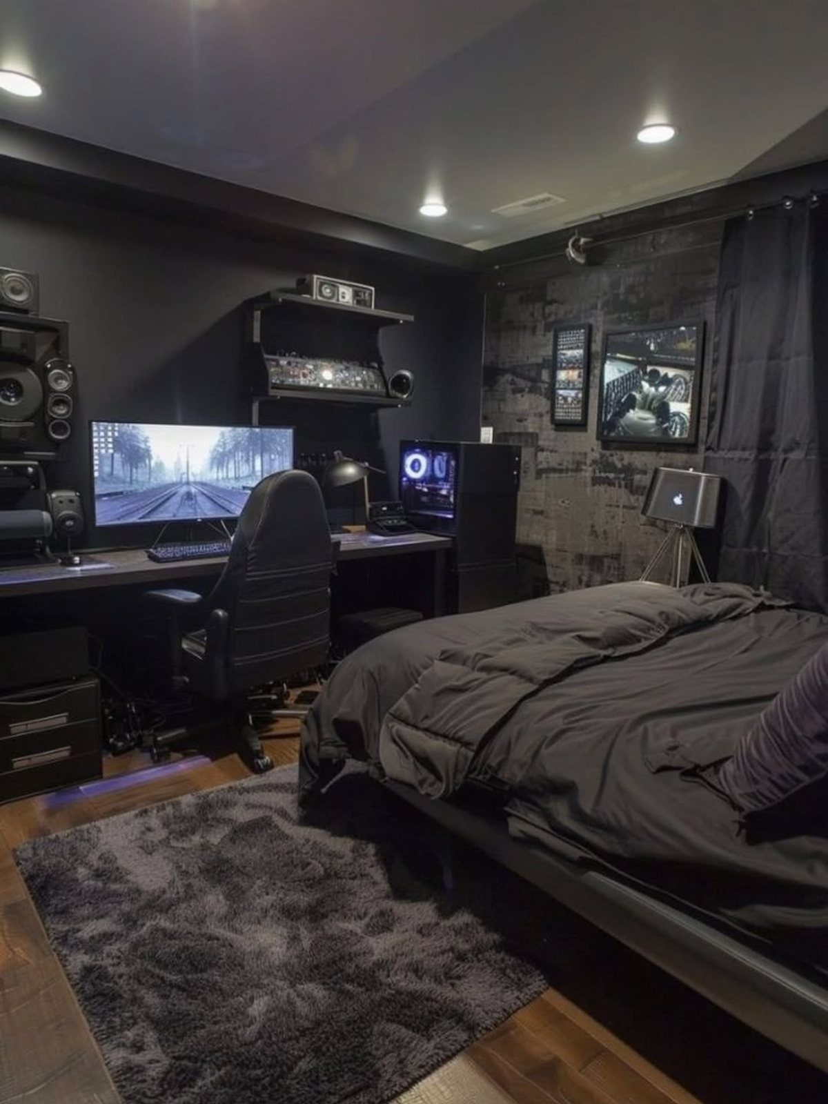 Black and grey bedroom with a gaming setup and dark grey bedding.