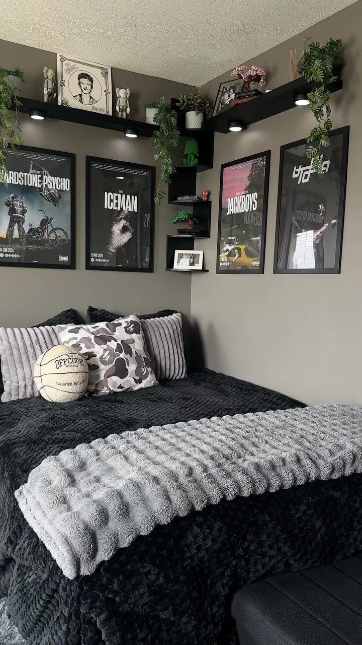 Bedroom with grey walls, black bedding, and framed posters on the wall.