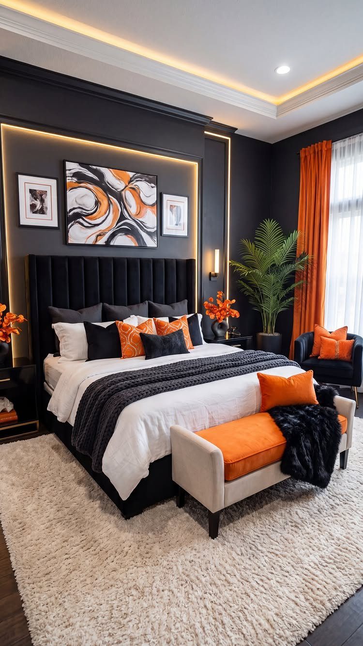 Matte black feature wall in a modern bedroom with orange accent pillows and bedding.