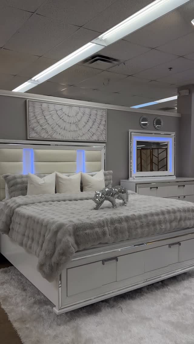 Modern white bedroom with grey faux-fur bedding and blue LED headboard lighting