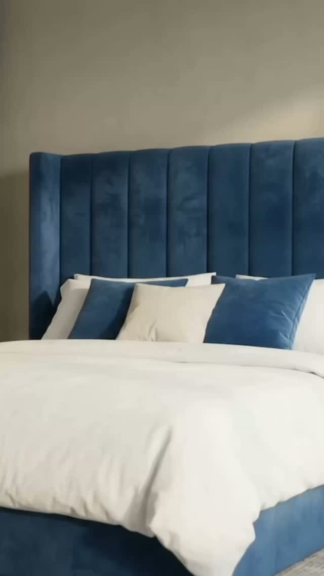 Blue velvet channeled headboard with white bedding and blue accent pillows.