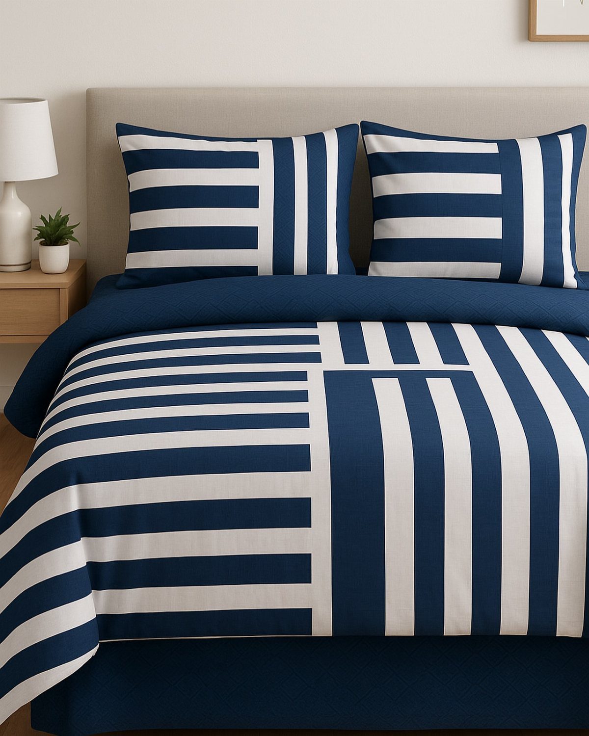 Navy blue and white striped bedding on a bed with a beige headboard.