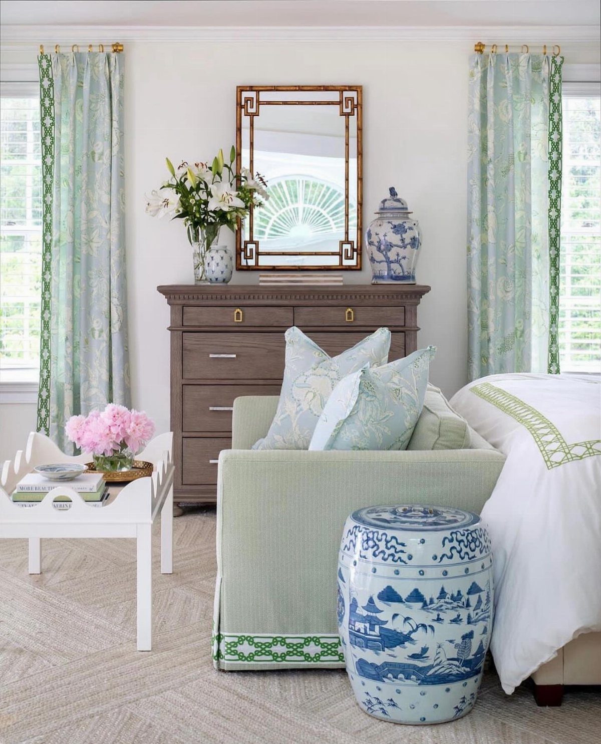 Blue and white ceramic garden stool and ginger jar in a bright bedroom.