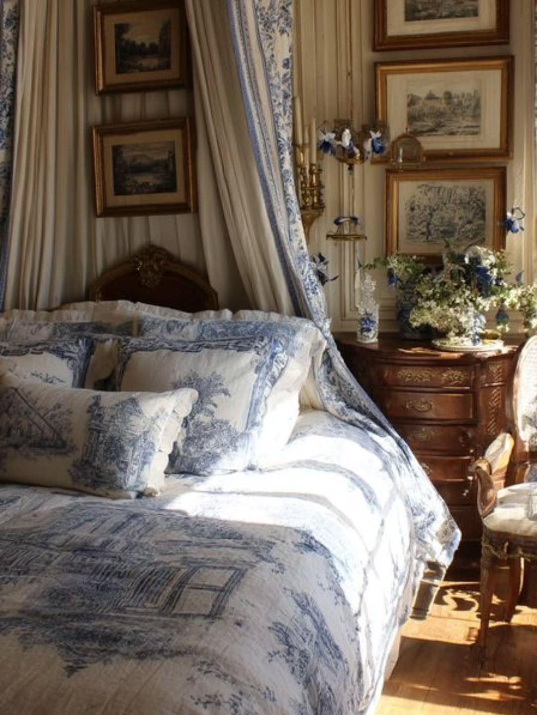 Blue and white toile canopy bed with matching bedding and wooden furniture.
