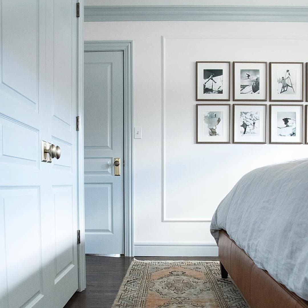 Light blue doors and trim in a white bedroom with blue bedding.