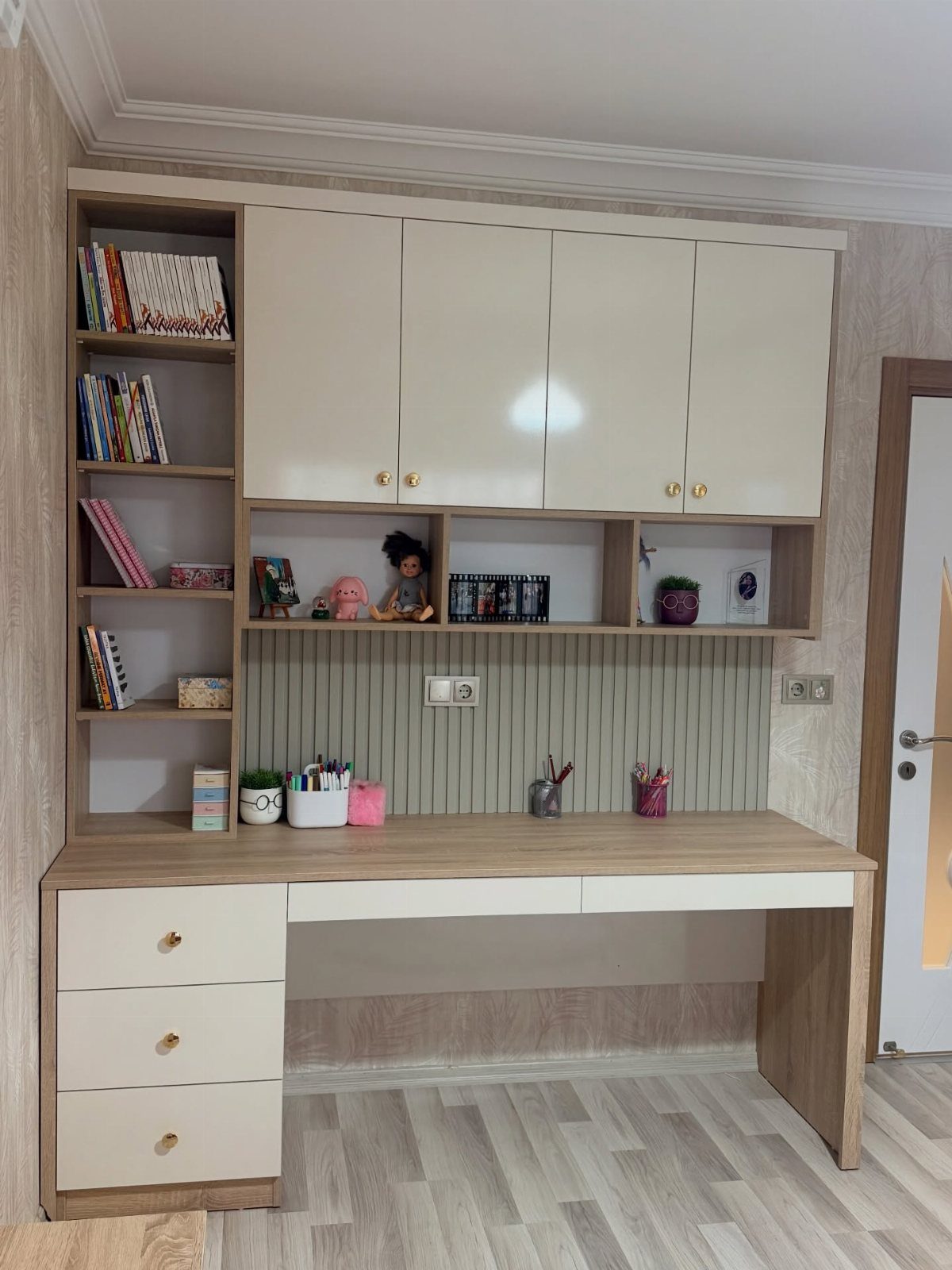 Built-in desk and bookcase unit with cream cabinets and light wood finish.