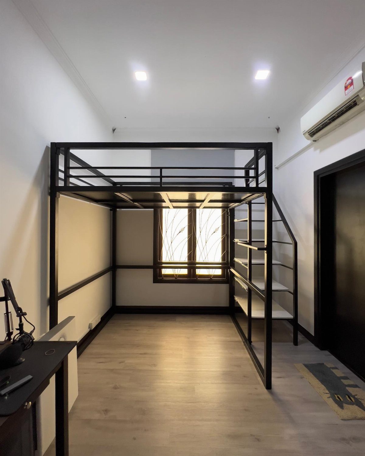 Black metal custom loft bed with integrated stairs in a modern white room.