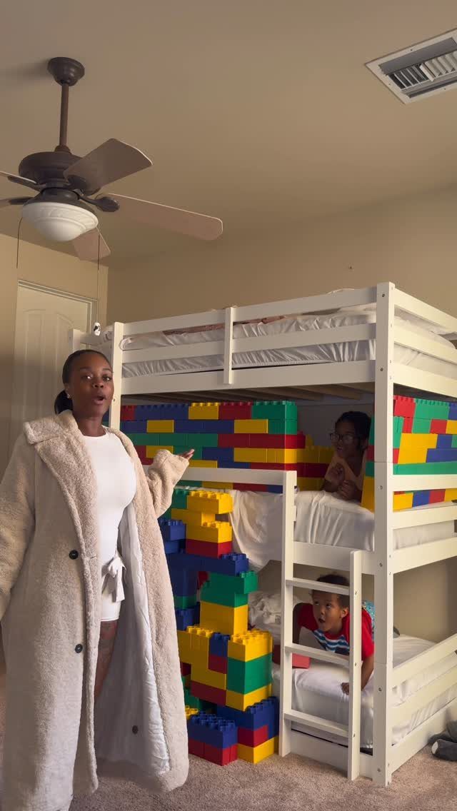 White bunk bed with a colorful plastic building block fort around the bottom bunk.