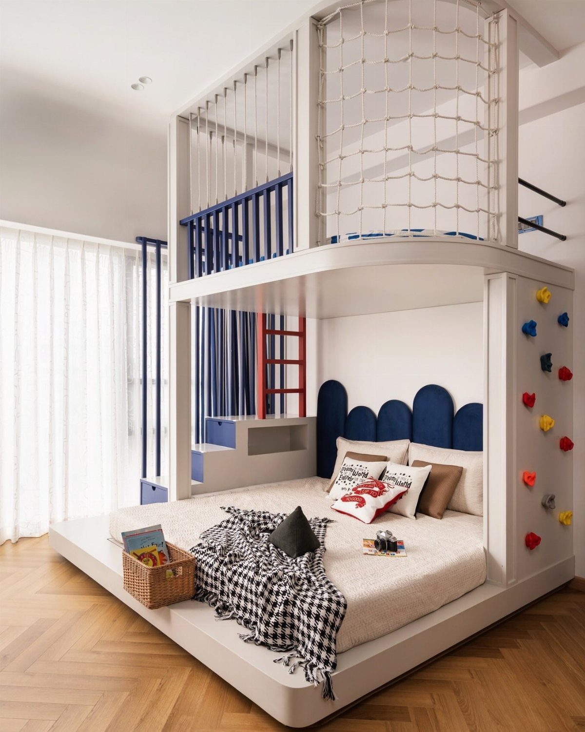 Modern white loft bed with climbing wall, rope netting, and blue railings.