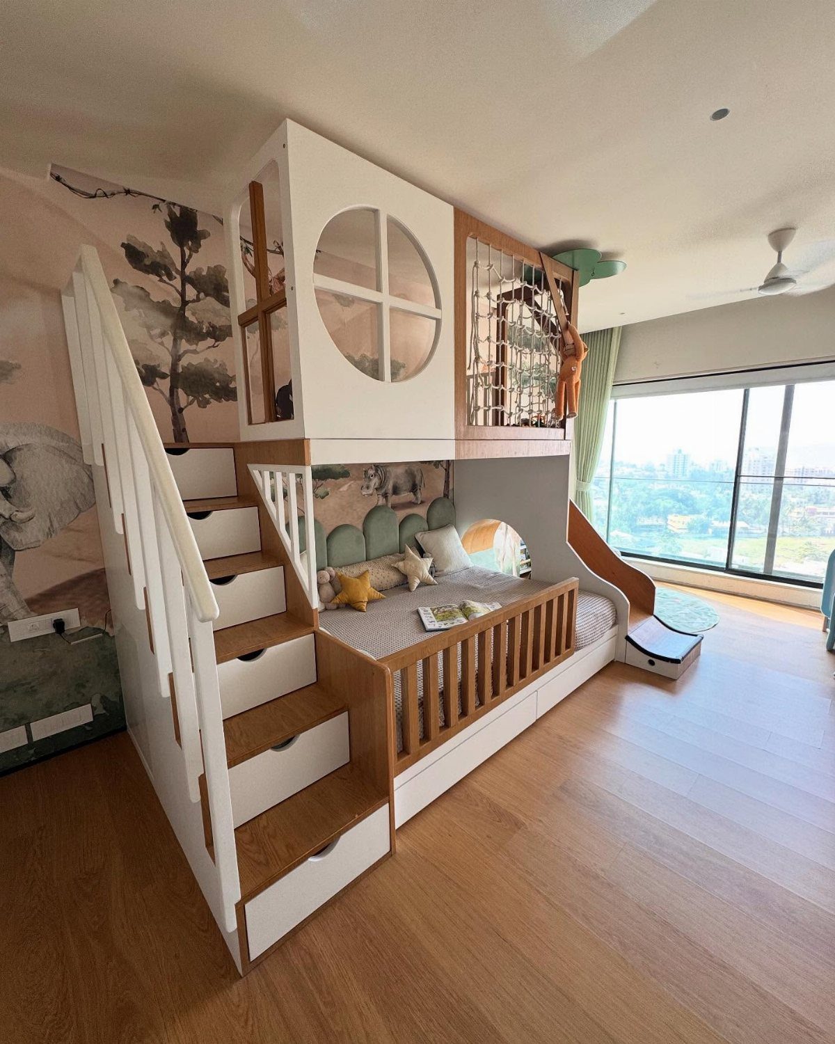 Loft bed with a slide and a cushioned reading alcove underneath.