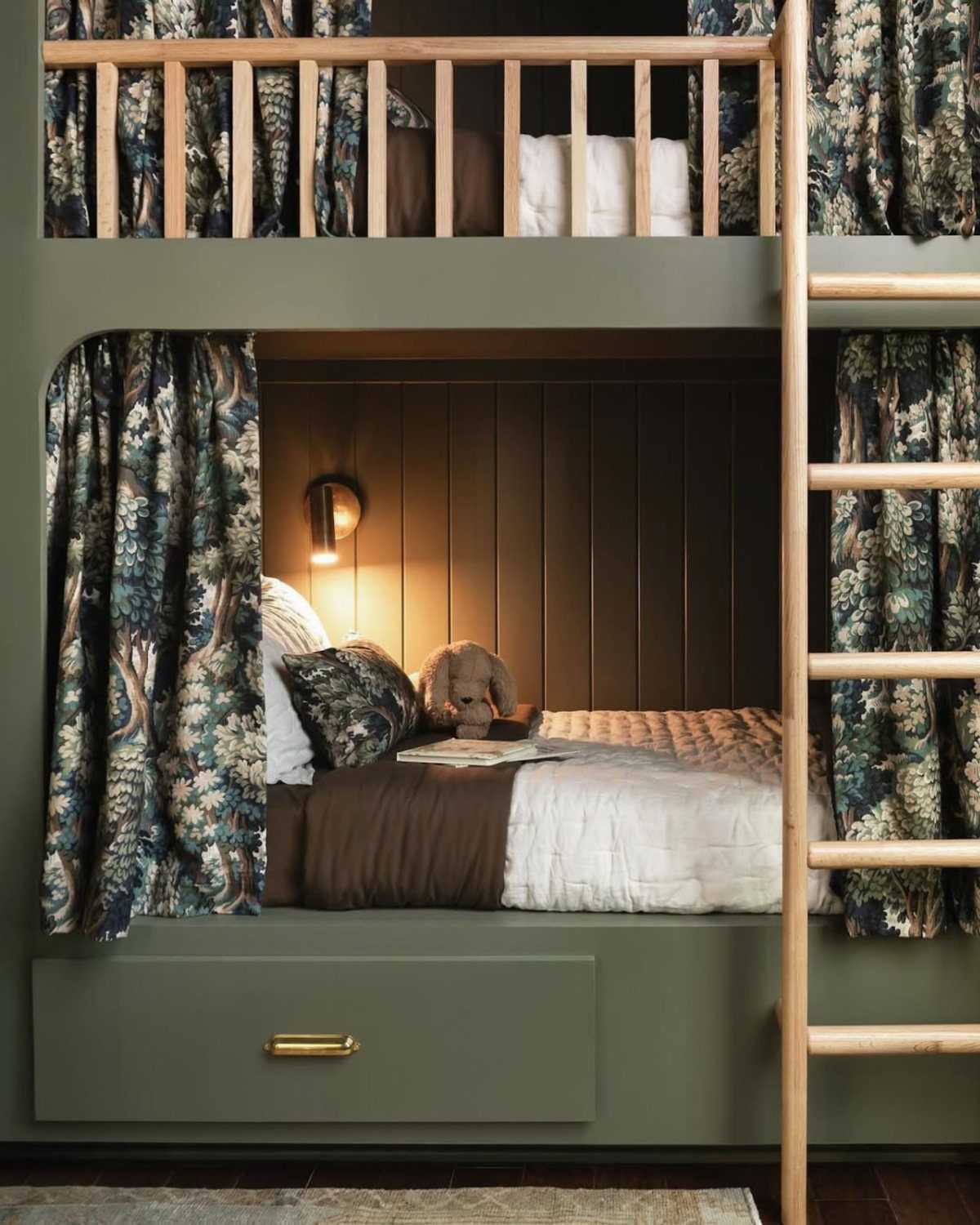 Bottom bunk bed with patterned curtains, warm lighting, and cozy bedding for reading.