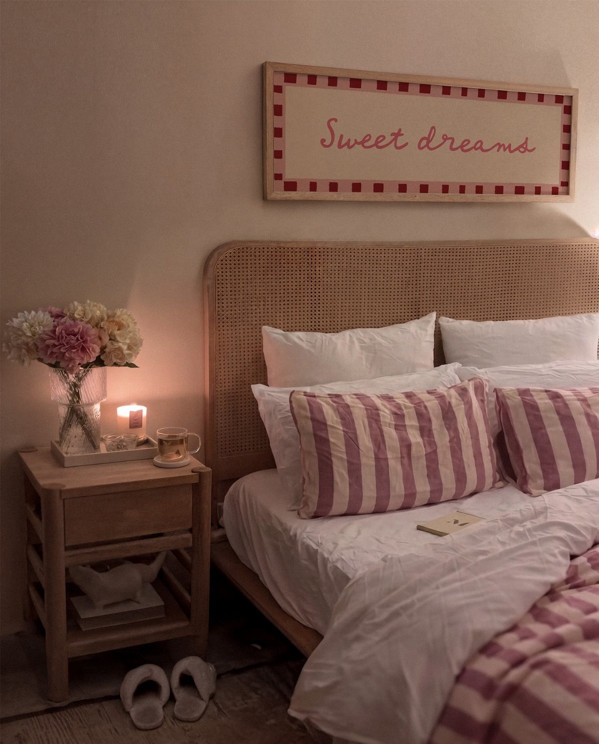Framed Sweet dreams sign hanging on a wall above a cozy bed headboard