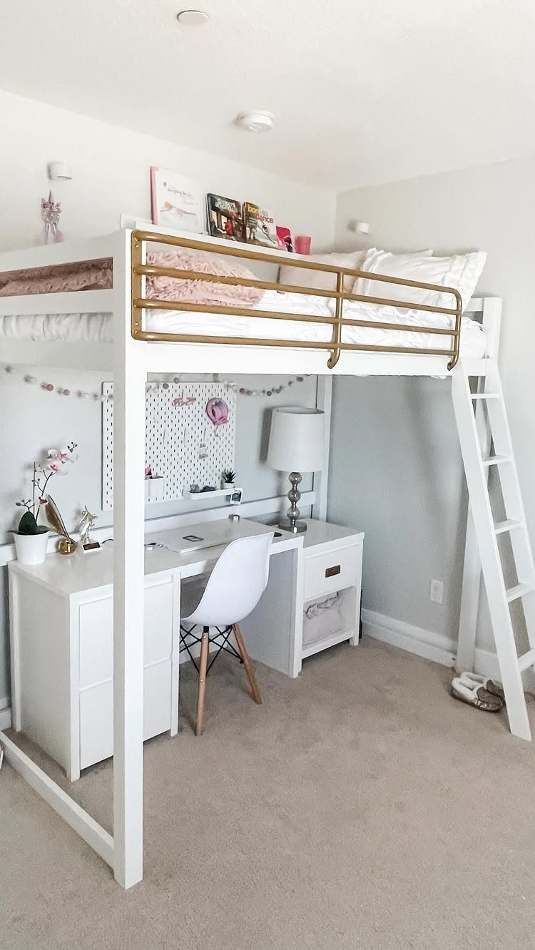 White loft bed with gold railing and a white desk underneath in bedroom