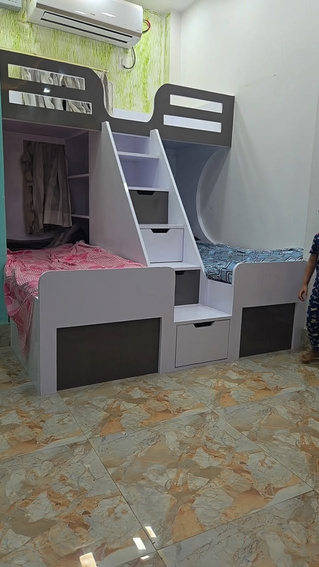 Modern grey bunk bed with a built-in storage staircase and white drawers.