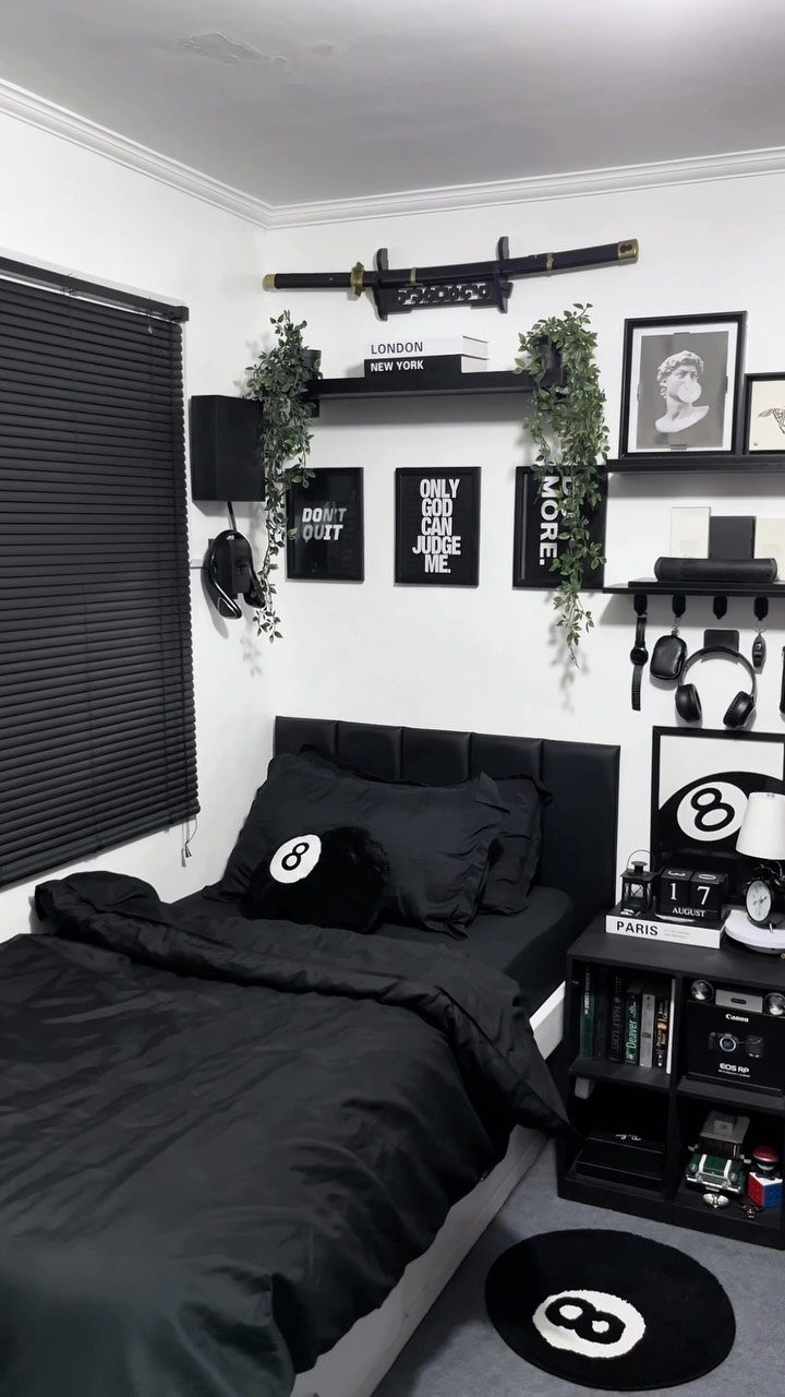 Black and white themed bedroom with 8-ball decor, black bedding, and wall shelves.