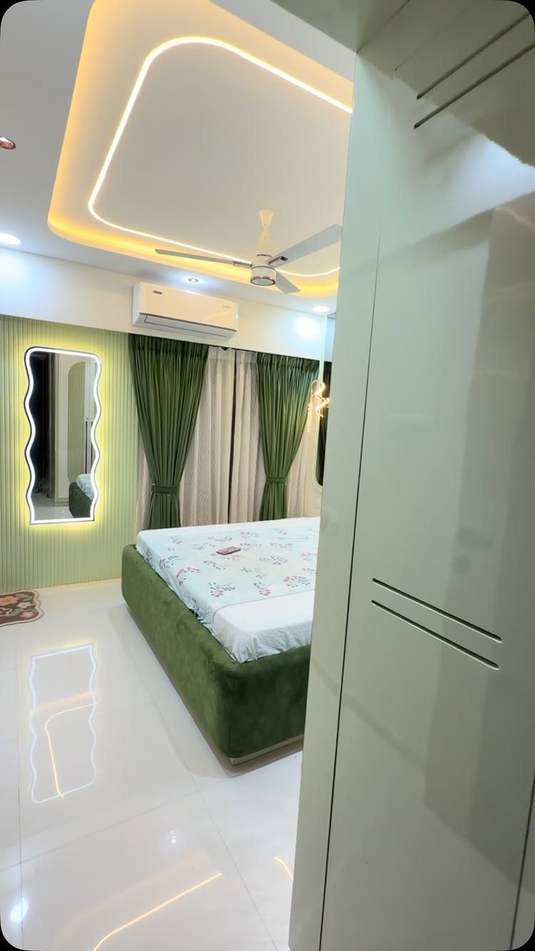 Green fluted feature wall with backlit wavy mirror in a modern bedroom