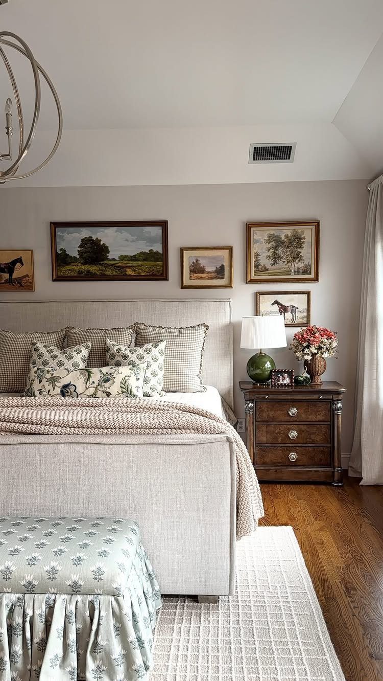 Framed art collection on a grey bedroom wall above a beige upholstered bed