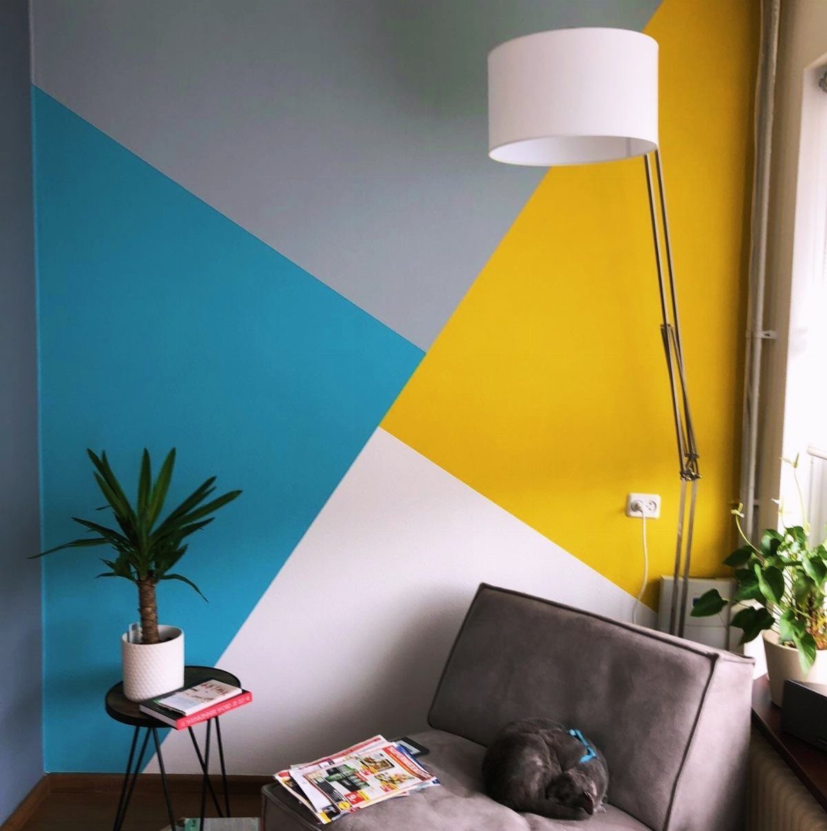 Geometric painted wall with blue, grey, and yellow blocks in a modern room