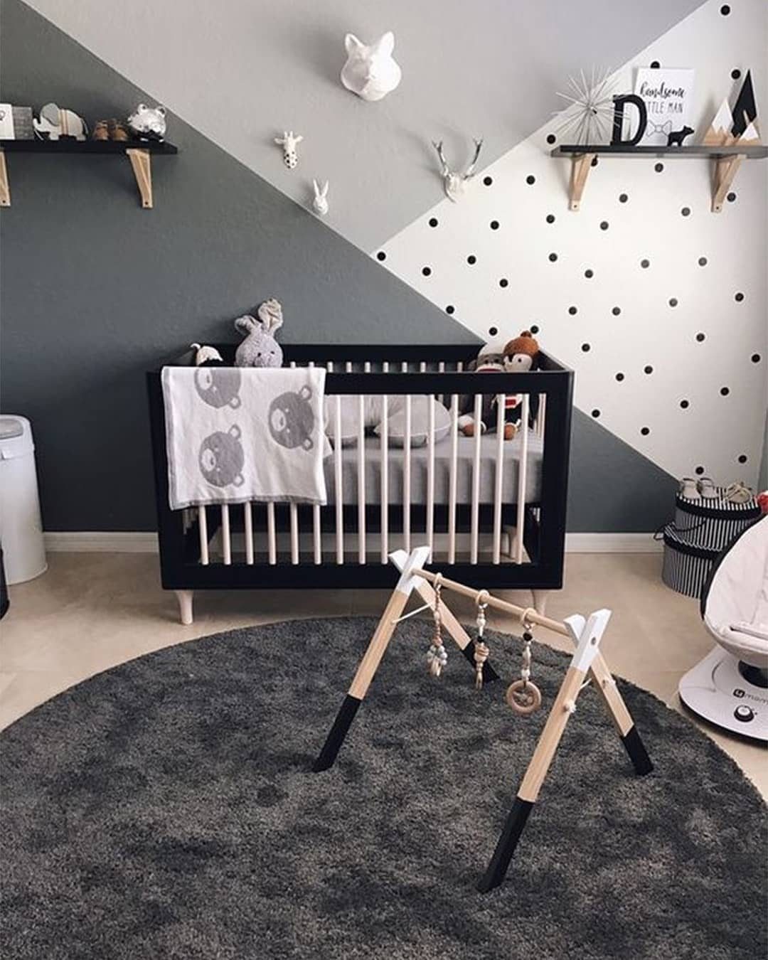 Black and white nursery with a polka dot wall and black crib.