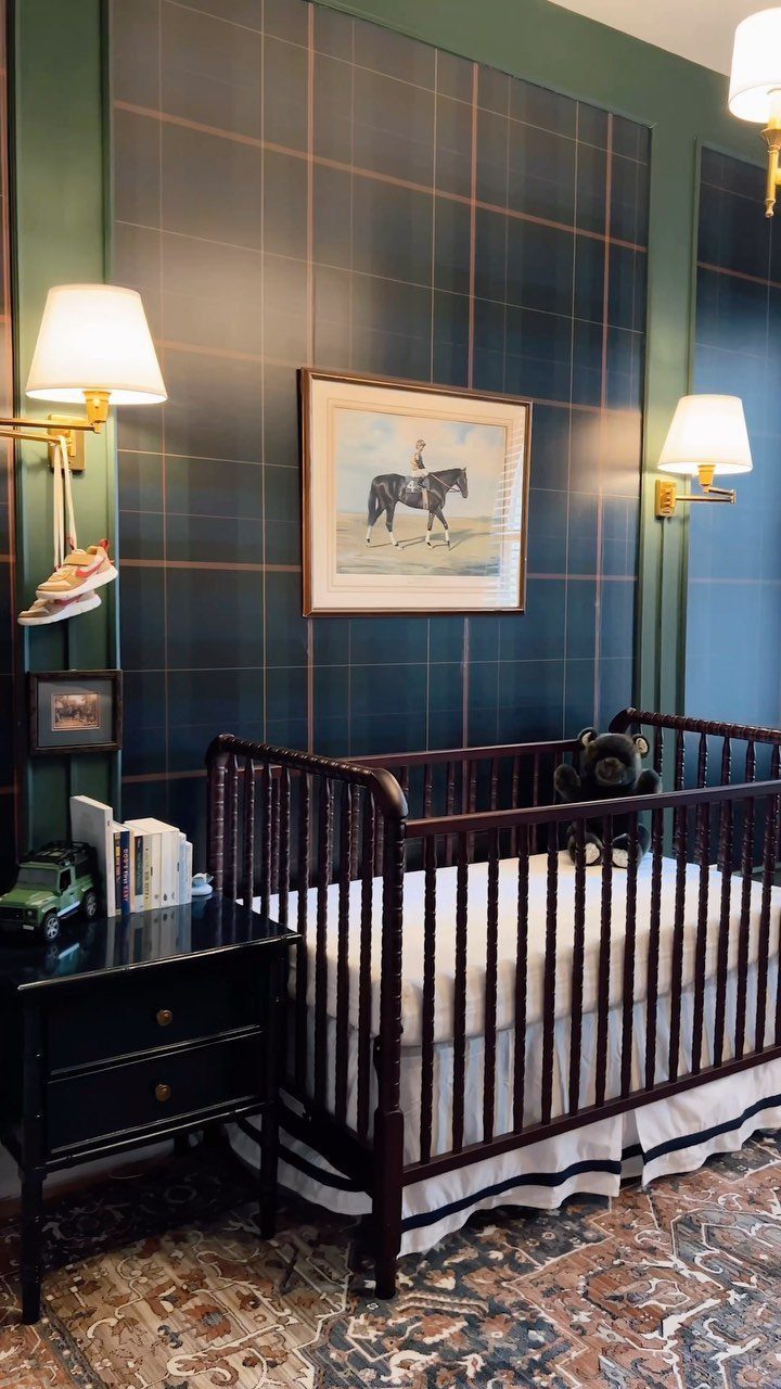 Dark wood crib in a nursery with teal plaid walls and horse artwork.