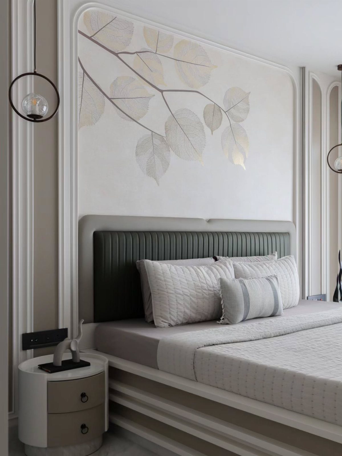 Modern bedroom with a dark green headboard, white bedding, and gold leaf wall art.