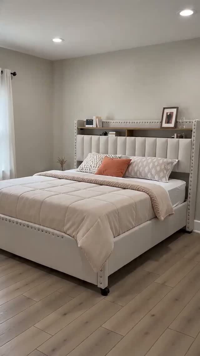 Upholstered bed with a built-in bookcase headboard holding a picture frame.