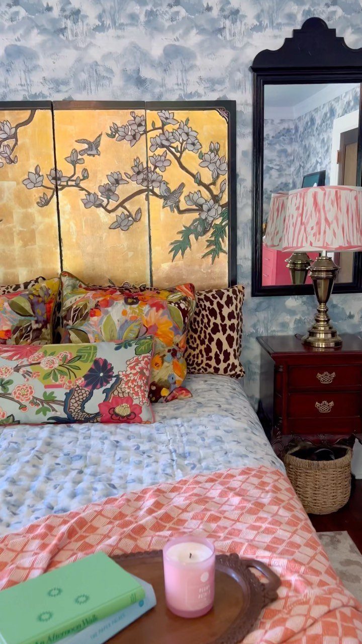 Gold triptych art used as a headboard on a bed with colorful pillows