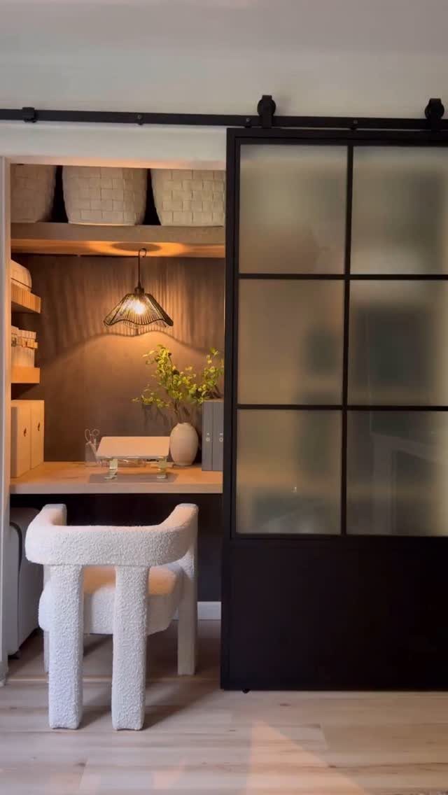 Small home office nook with a white chair and black sliding glass door.